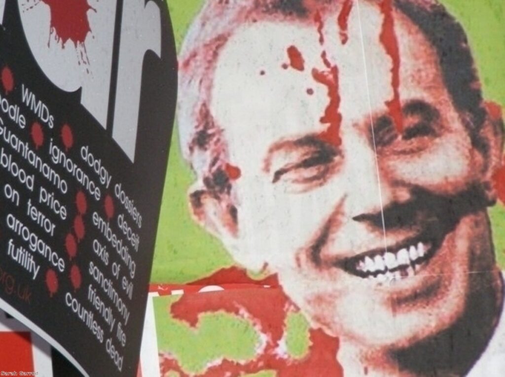 A protestor holds up an anti-Blair banner during his last evidence session