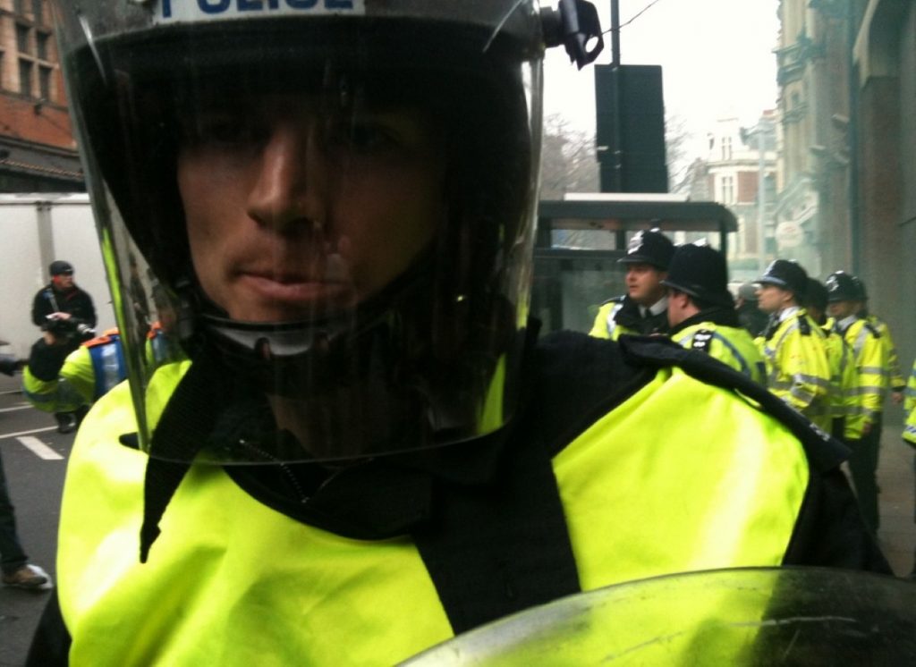 A riot policeman looks on as violent protests take place against spending cuts last month