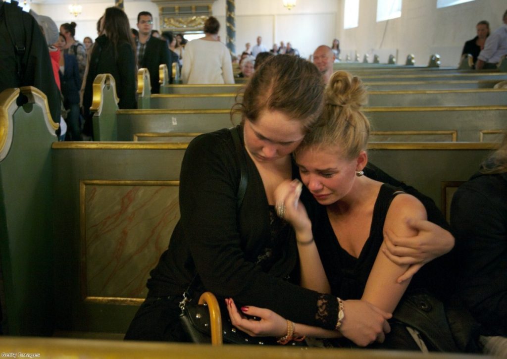 Young girls comfort each other in the wake of the Norway shootings.