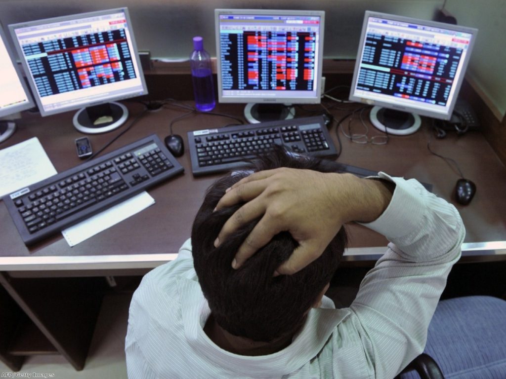 A stockbroker watches share prices on his computer at a brokerage firm in Mumbai yesterday.