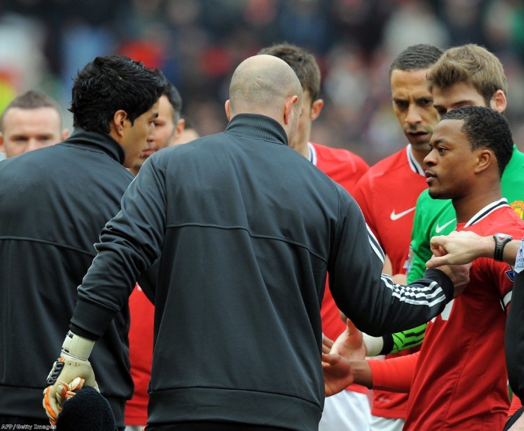 Rio Ferdinand looks disgusted as Suarez fails to shake Evra's hand