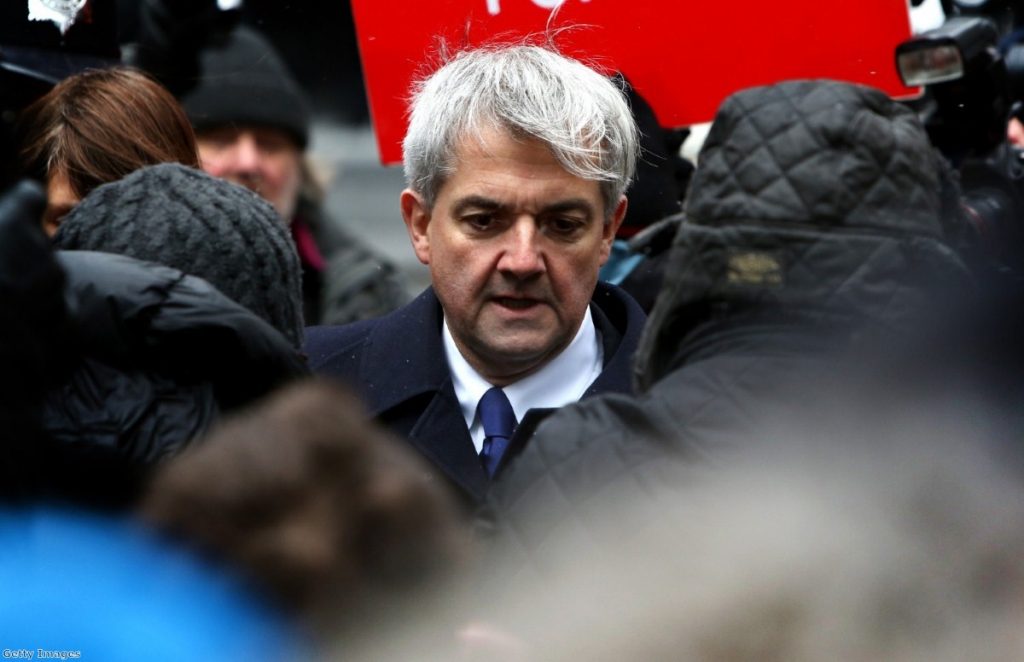 Chris Huhne arrives in court amid a media scrum today.