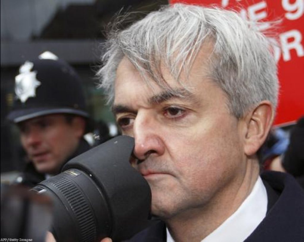 Chris Huhne arrives in court amid a media scrum today 