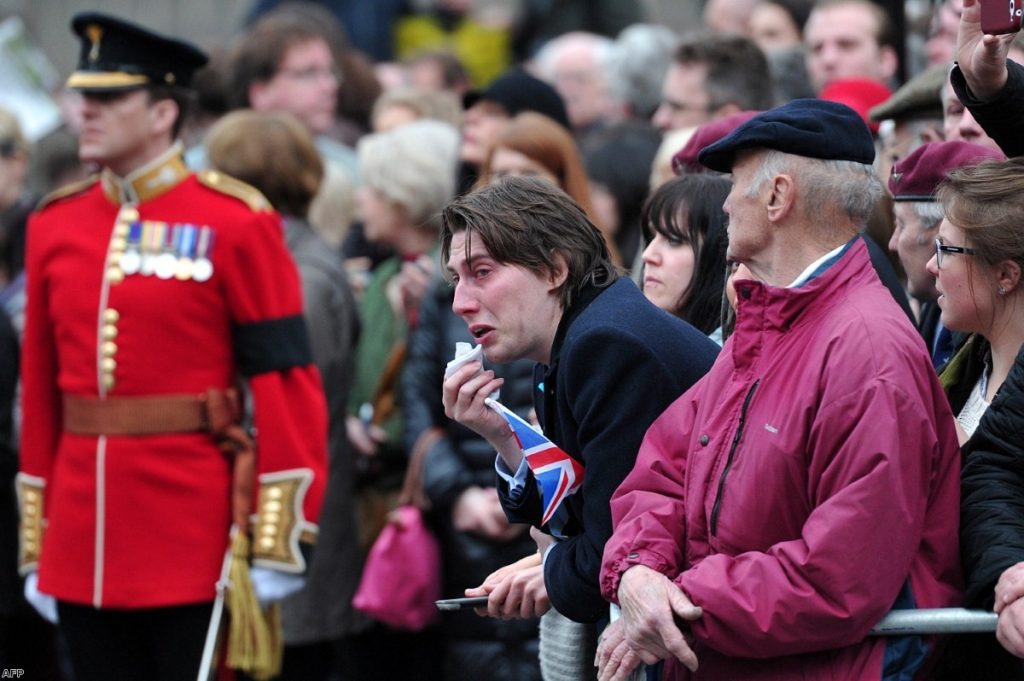 A mourner weeps as Margaret Thatcher's coffin is brought to St Paul's cathedral