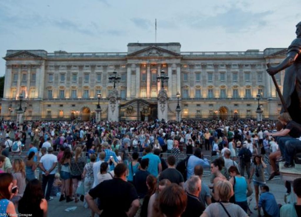 Crowds outside Buckingham Palace press to see the 'ornate easel' announcing the royal birth