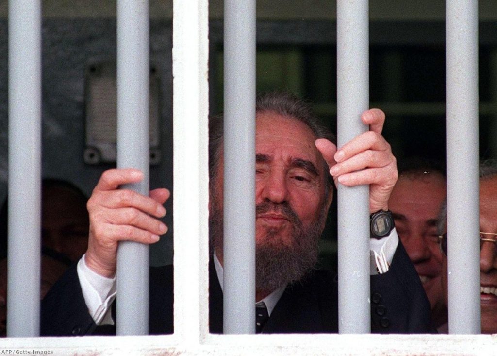 Fidel Castro peers out of the bars of Nelson Mandela's former cell on Robben Island during a recent visit.