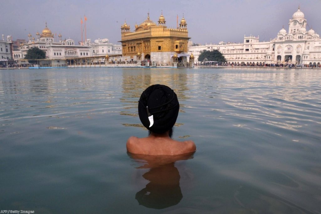 A Sikh takes a dip in the holy sarover at the Golden Temple in Amritsar last Tuesday. The massacre was a defining moment for many Sikhs around the world.