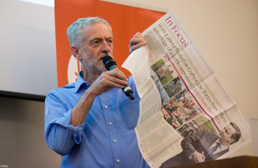 Jeremy Corbyn holds up a newspaper article as he speaks at a rally for supporters on August 25, 2015 in Southampton
