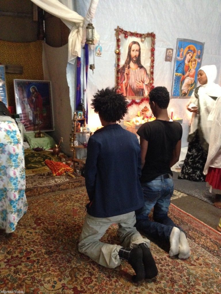 Refugees pray at a makeshift church in the Calais camp. French authorities plan to demolish the so-called Jungle. 