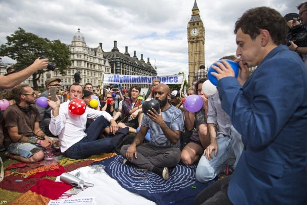 Protesters stage a mass inhalation of laughing gas, outside the Houses of Parliament 