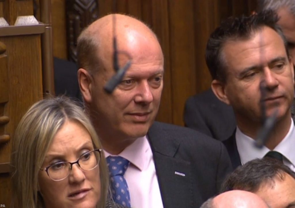 Chris Grayling watches on during PMQs. The transport secretary fails either upwards or sideways.