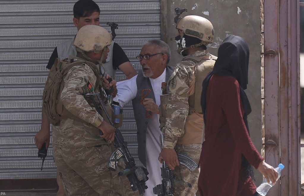 Afghan security officers stop a man near the site of an explosion in Kabul last Wednesday.