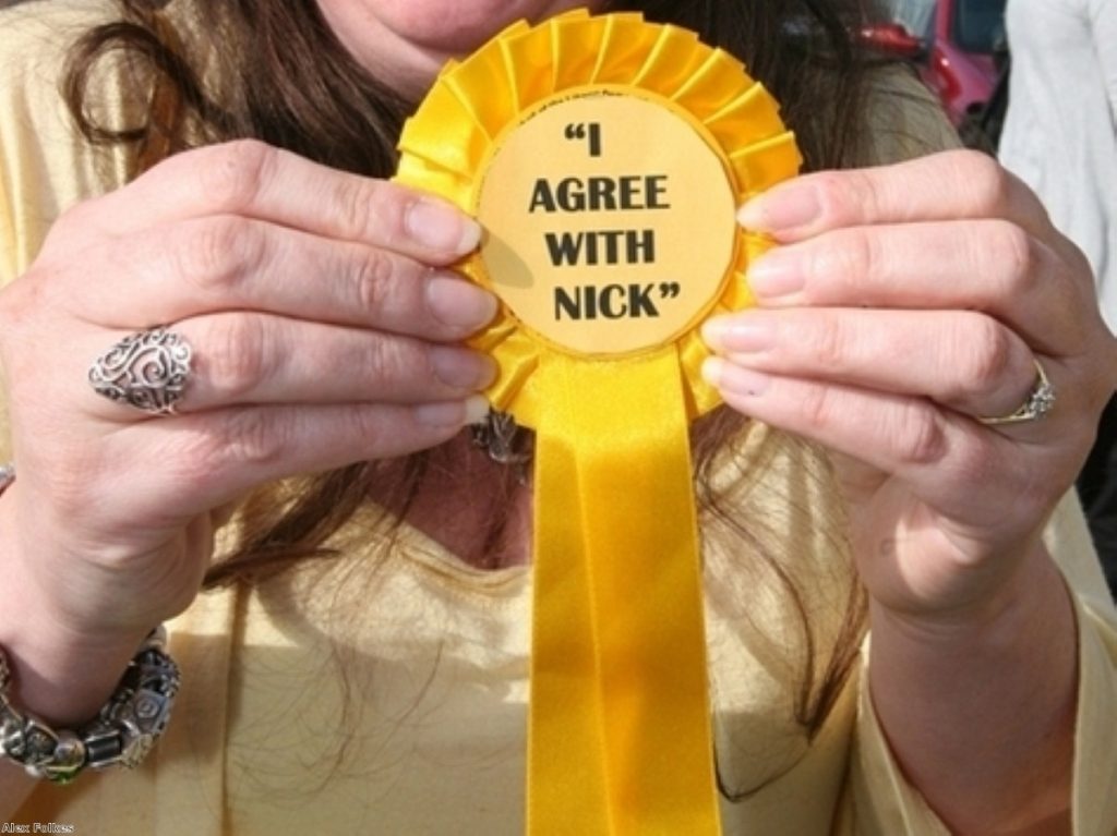 A supporter holds up a Lib Dem rosette mocking Gordon Brown's attempts to gang up with Clegg last Thursday