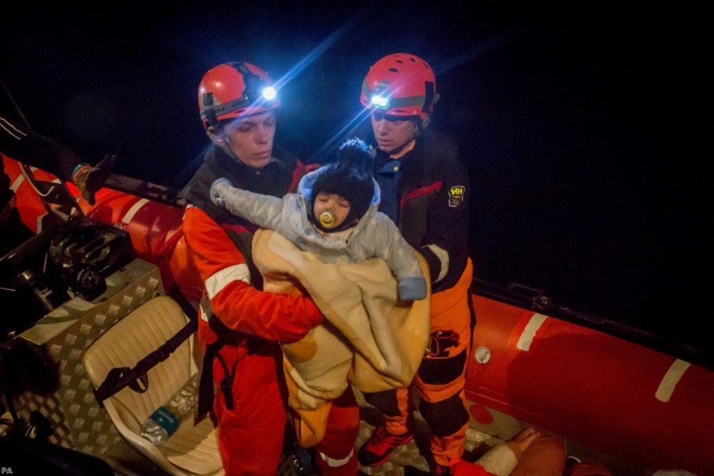 A young child is rescued from a boat by the crew of the Alan Kurdi rescue ship, operated by German charity Sea-Eye, in December last year.  