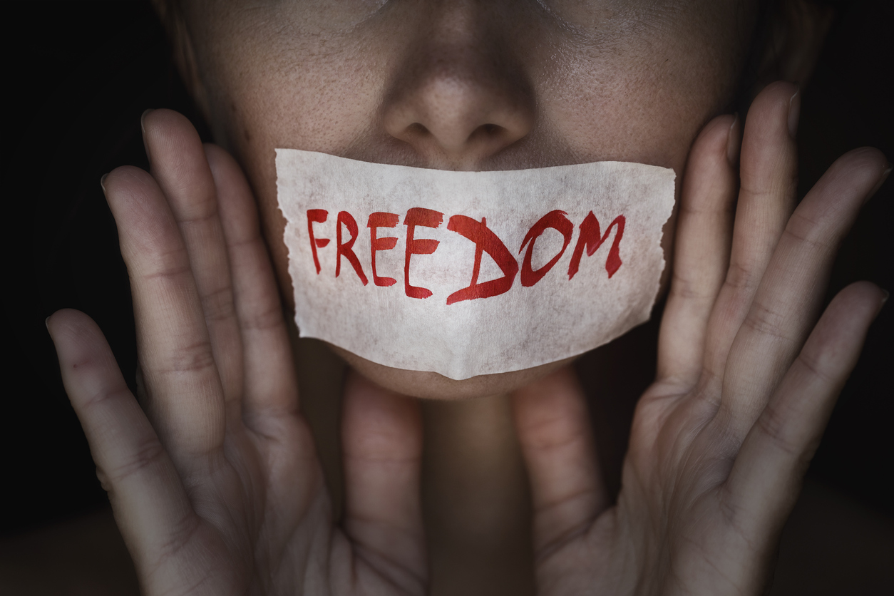 Concept of freedom speech: mouth of a person is sealed with an adhesive tape, closeup