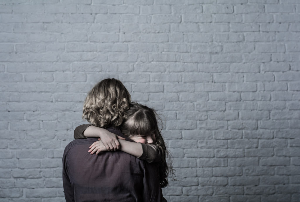 Girl hugging mother.